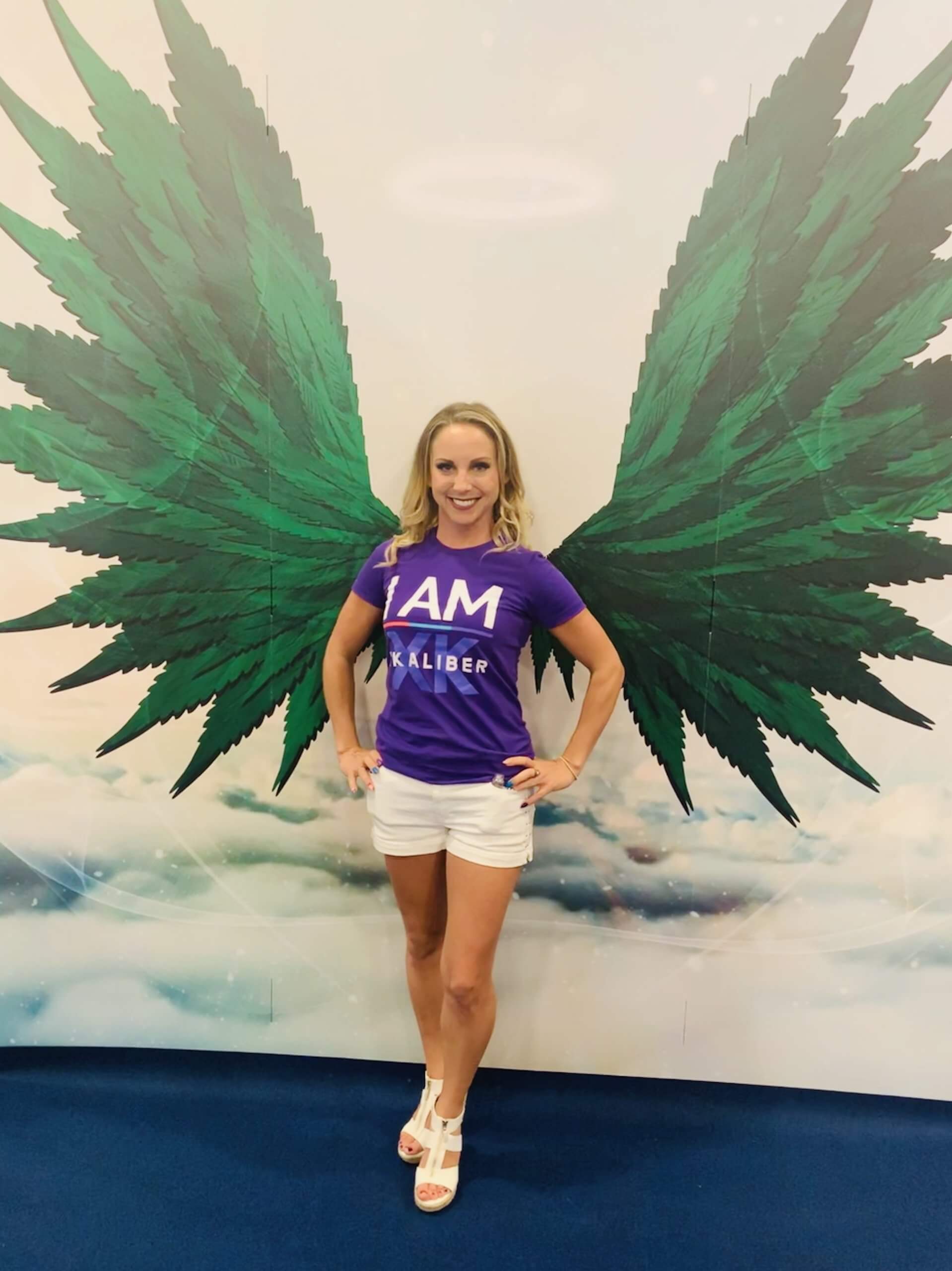 Queen of CBD | Mia Shark Mia Shark standing in front of a green wing mural